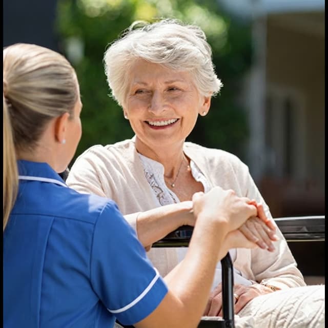 Nurse smiling with an elderly Sheffield resident outdoors
